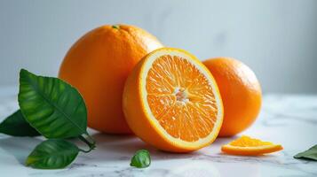 Fresh vibrant orange fruit with citrus slices and green leaves on a marble background photo