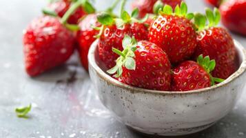 Fresh strawberries in a ceramic bowl, ripe and juicy fruit with a vibrant red color photo