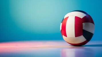 Volleyball sport equipment captured with dynamic red, white, blue colors and reflection on indoor court surface photo
