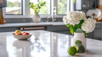 Modern kitchen with quartz countertop featuring flowers, apples, vase, interior design elements photo