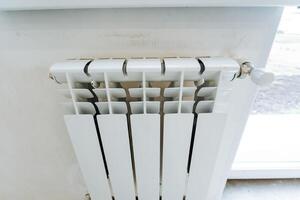 Heating in the house, white metal radiator, room heating in winter, heat deficit in Europe. photo