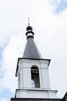 el campana torre, el blanco torre de el Iglesia Iglesia con campanas, el bronce campana, el campana campanero, a distribuir el sonido a el todo distrito. foto