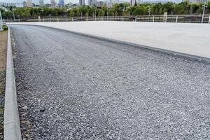 Repair of a pedestrian road, laying rubble on the road, a concrete curb, a park area, a sidewalk for pedestrians, road works, city park construction. photo