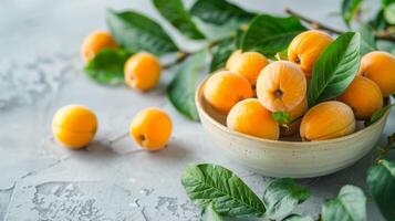 Fresh ripe loquats in a bowl with leaves on a textured table photo