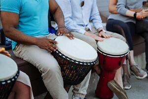 músicos tambor en el calle, un grande negro chico late el ritmos de África en un djamba, bombeado músculos, bíceps. foto