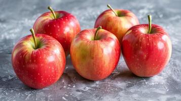 Red apples on a textured surface portraying freshness and healthy nutrition photo