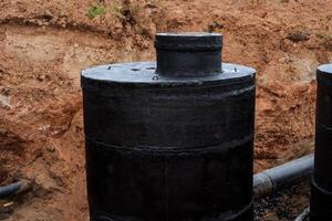 alcantarillado es excavado en el suelo, impermeabilización con negro resina, cubierta el bien con un protector compuesto, agua suministro instalación de hormigón bloques, redondo Bueno. foto