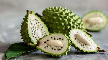 Soursop seeds within a tropical fruit display featuring sliced exotic Annona muricata photo