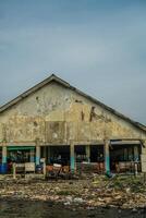 Jepara, Central Java, April 7, 2024 - The building where the fish auction is located is starting to erode with age, with rubbish strewn along the side of the building. photo