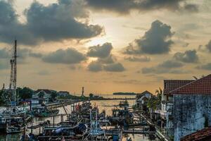 Jepara, Central Java, April 7, 2024 - Jepara fishing boats parked in a crowded harbor against the backdrop of the evening sky with empty space for advertising photo