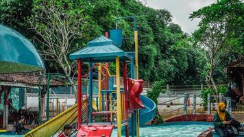 jepara, central Java, abril 14, 2024 - nadando piscina paseos para niños con vistoso diapositivas foto