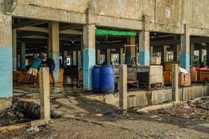 Jepara, Central Java, April 7, 2024 - The building where the fish auction is located is starting to erode with age, with rubbish strewn along the side of the building. photo