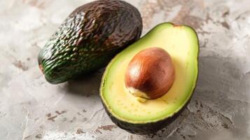 Fresh halved avocado with seed showcases green, ripe, nutrient-rich fruit for healthy cooking photo