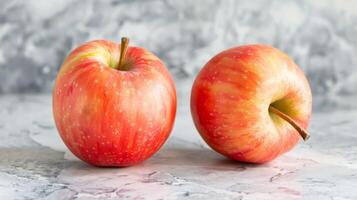 de cerca de dos rojo manzanas exhibiendo frescura y vibrante colores en un texturizado superficie foto