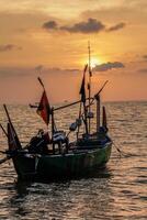 fishing boats on the sea against an orange sky at night with empty space for photocopies. photo