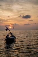 fishing boats on the sea against an orange sky at night with empty space for photocopies. photo