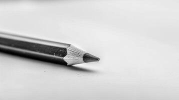 Closeup of a sharp graphite pencil tip art tool with a monochrome blurred background photo