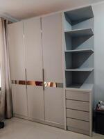 wardrobe with three doors with hanging shelves and drawers to the left of the cupboard. photo