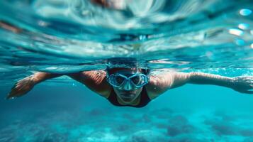 Swimming woman underwater with goggles demonstrates freestyle technique in pool photo