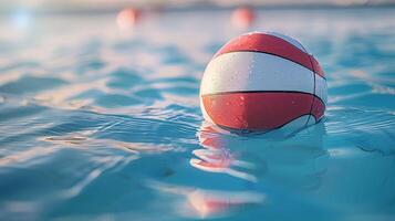 Water polo ball floating in the pool with sunlight reflecting off the red and white surface during a sports competition photo