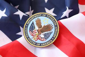 KYIV, UKRAINE - MARCH 9, 2024 US Department of Veteran Affairs seal on United States of America flag photo