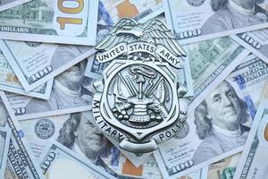 KYIV, UKRAINE - MARCH 9, 2024 US Army Military Police badge on many US hundred dollar bills photo