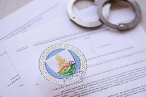 KYIV, UKRAINE - MARCH 9, 2024 US Department of Agriculture seal with handcuffs on many US District Court warrants and complaints photo