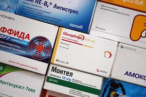 KYIV, UKRAINE - 4 MAY, 2023 Many boxes of pills and capsules stacked in pharmacy drug store photo