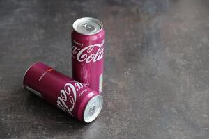 KYIV, UKRAINE - 4 MAY, 2023 Coca cola soft drinks brand tin cans with cherry flavour photo