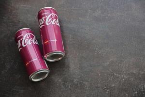 KYIV, UKRAINE - 4 MAY, 2023 Coca cola soft drinks brand tin cans with cherry flavour photo