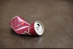 KYIV, UKRAINE - 4 MAY, 2023 Coca cola soft drink crumpled tin can with cherry flavour photo