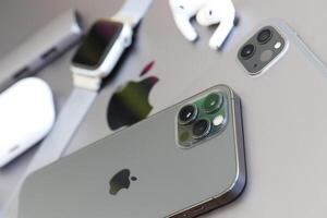 KYIV, UKRAINE - 4 MAY, 2023 Apple brand devices iphone, ipad and airpods with apple watch lies on macbook body photo