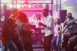 joven amigos grupo ir de fiesta en pista de baile y improvisando danza batalla en Club nocturno. diverso personas clubbing a discoteca mientras relajante y disfrutando la vida nocturna ocio foto