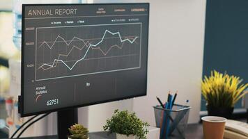 Business graphs and figures on laptop showing upward profit trend on desk next to wheelchair. Economic annual report charts on notebook in inclusive company office for workers with disability photo