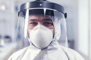 retrato de bioquímico en Ciencias laboratorio vistiendo ppe equipo para COVID-19. sobrecargado de trabajo investigador vestido en protector traje en contra invección con coronavirus durante global epidemia. foto