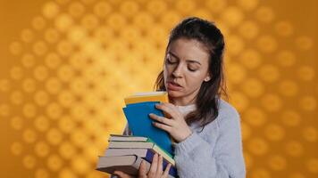 emocionado mujer hojeada aunque pila de comprado libros, cosecha qué a leer. entusiasta adicto a los libros persona mirando mediante apilar de novelas a gastar ocio hora con, estudio fondo, cámara si foto