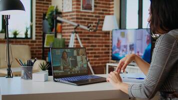 Remote professional holding q and a session with webinar participants via videoconference meeting in cozy apartment. Online videocall host engaging in online discussions with trainees, camera A photo