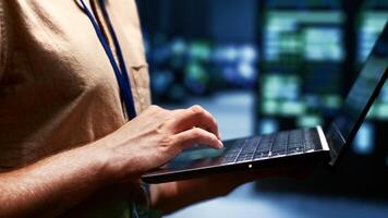 Close up shot of technician writing server farm disaster recovery plan on laptop to provide rapid restoration of service, limiting disruption and minimizing interruptions to normal operations photo