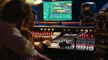 guitarrista grabación su electro acústico instrumento y canción en estudio, productor nuevo música con un sonido ingeniero en controlar habitación. experto músico compositor de canciones grabación pistas cámara una. foto