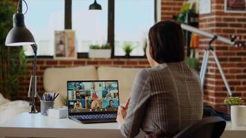 Remote employee in stylish apartment talking with coworkers during teleconference meeting. Teleworker at home participating in internet videocall with colleagues, camera B photo