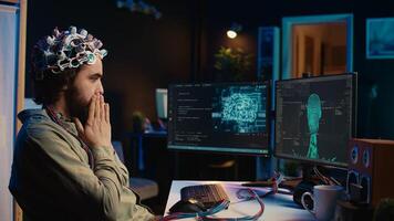 IT technician using EEG headset stupefied after mind upload virtual process is successful. Man astounded after achieving goal of transferring consciousness into computer cyberspace, camera B photo