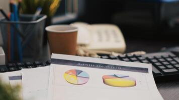 Cup of coffee and paperwork on office desk containing company profit analysis, close up shot. Business documents, hot beverage and telephone on table in accounting workplace photo