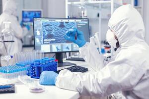 Lab worker preparing test blood for detection of coronavirus dressed in ppe. Doctor working with various bacteria and tissue, pharmaceutical research for antibiotics against covid19. photo