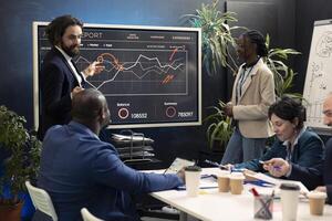 Marketing team assembling in an information sharing meeting to review updates on regulatory changes or industry standards. Business employees reviewing data analysis infographics. photo