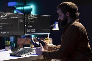 Programmer putting headphones on while implementing security measures to protect company systems and data. IT admin listening music, testing and debugging code for software applications photo