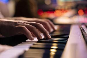 músico jugando electrónico teclado sintetizador en profesional estudio, creando canciones y trabajando con productor en nuevo álbum. talentoso cantante composición música en electrónico teclado. cerca arriba. foto