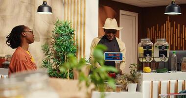 vegano mujer que se acerca revisa mostrador a comprar producir, elegir orgánico recién cosechado frutas y vegetales a agricultores mercado. cliente hablando a comerciante acerca de sano nutrición. cámara 2. foto