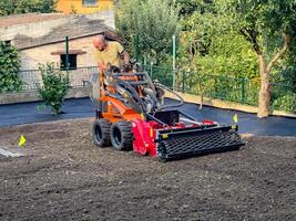 Nitra, Slovakia - 08.15.2023 Operation of a mechanical seeder. Planting a lawn. photo