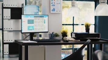 Empty office with stock portfolio on computer monitor containing collection of investment bonds and other financial assets. Real time index indices showing stock demand surge on PC, panning shot photo