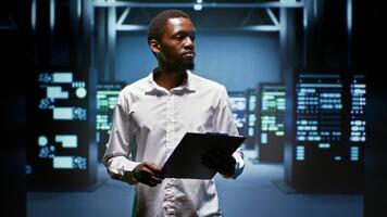 African american engineer doing maintenance in data center providing vast computing resources and storage, enabling artificial intelligence to process massive datasets for training and inference photo